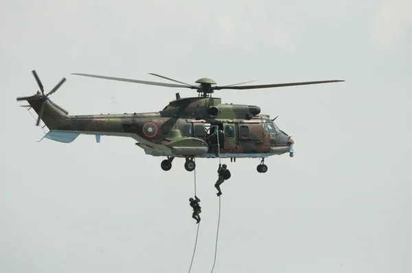 Dois soldados pendurados num helicóptero — Fotografia de Stock
