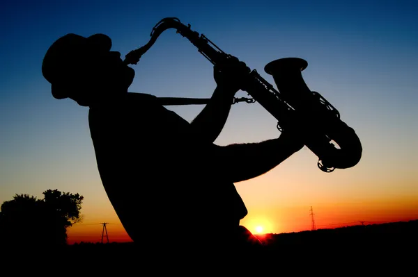 Saxofonist bij zonsondergang — Stockfoto