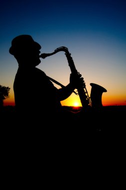 Saxophonist at sunset 2 clipart