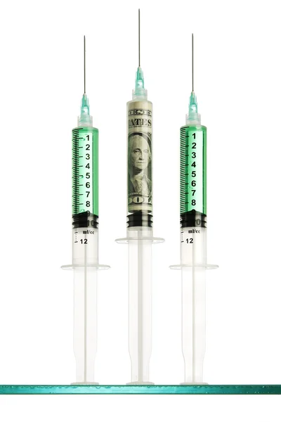 Syringes, one filled with a dollar bill — Stock Photo, Image