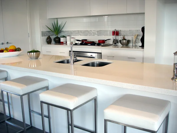 Cozinha espaçosa em plano aberto branco com bar de pequeno-almoço — Fotografia de Stock