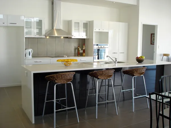 Spacious white open plan kitchen with breakfast bar — Stock Photo, Image