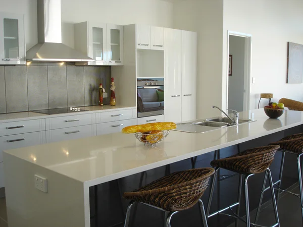 Cozinha espaçosa em plano aberto branco com bar de pequeno-almoço — Fotografia de Stock