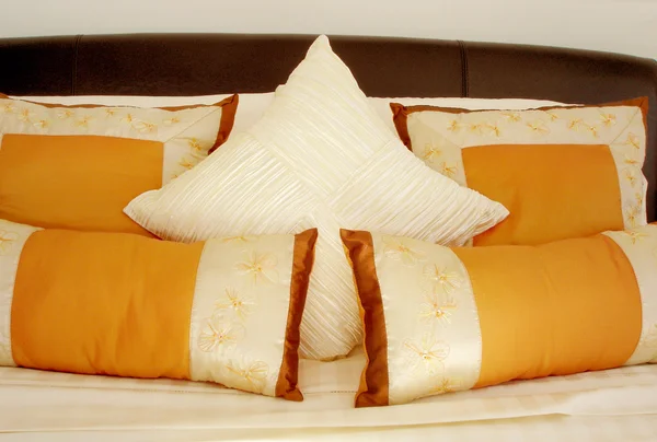 Orange cushions on the bed — Stock Photo, Image