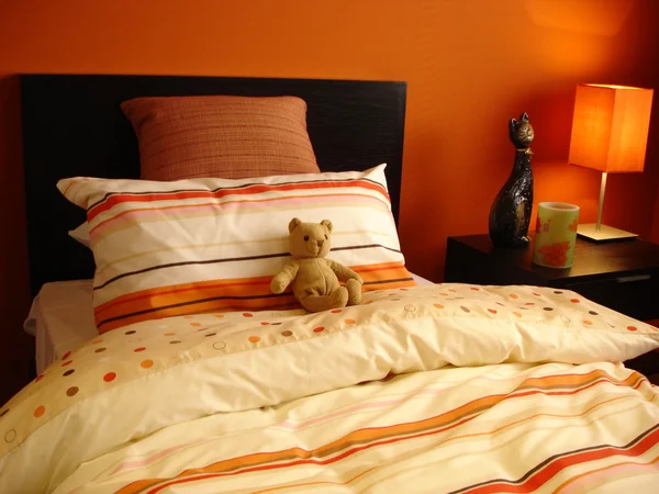 Orange Schlafzimmer mit Teddybär — Stockfoto