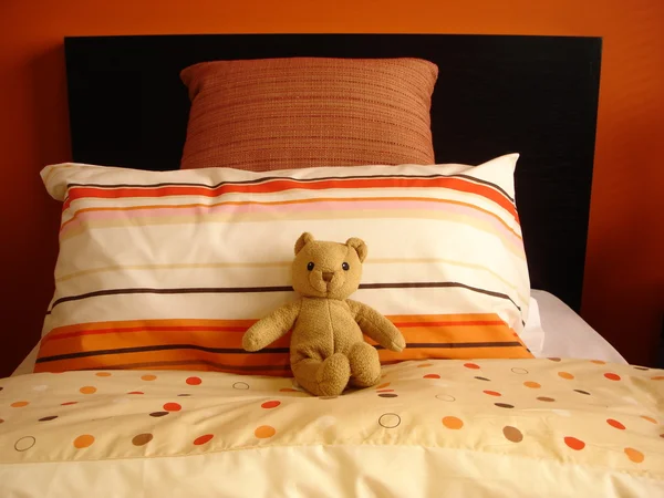 Orange bedroom with teddy bear — Stock Photo, Image