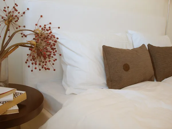 Knackig weißes Schlafzimmer mit braunen und roten Akzenten — Stockfoto
