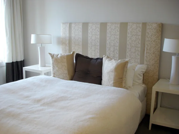 现代卧室柔和的色调与高条纹床头板 — 图库照片