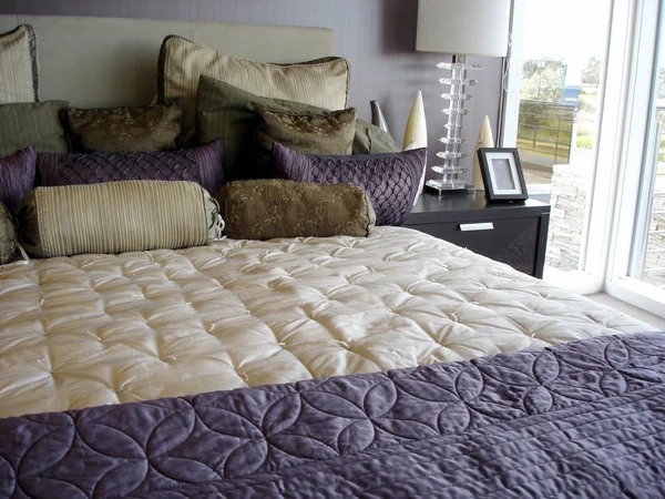 Moderne glamoureuze paarse slaapkamer Stockfoto