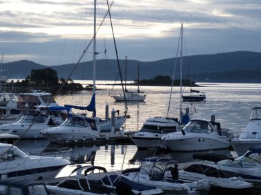 Boats moored at sunset clipart