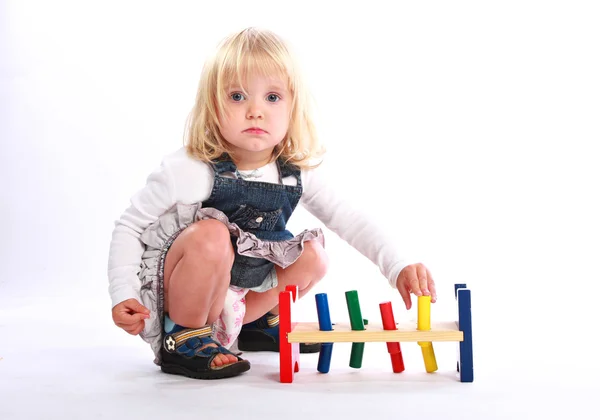 小さな女の子が遊んで、カラフルなおもちゃ — ストック写真