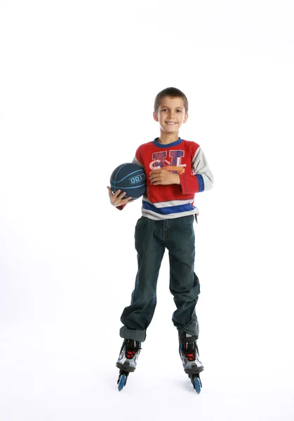Niño en patines sosteniendo una pelota — Foto de Stock