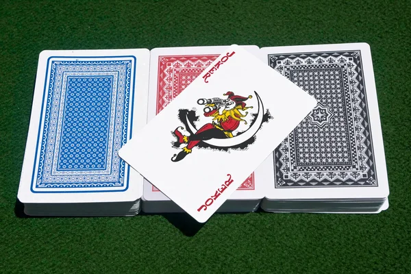 Brincalhão sobre três baralhos de cartas — Fotografia de Stock