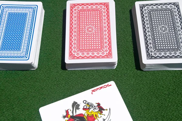 Drie speelkaarten met rode joker — Stockfoto