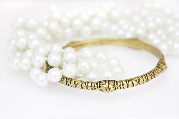 Brass bracelet and imitation pearls — Stock Photo, Image