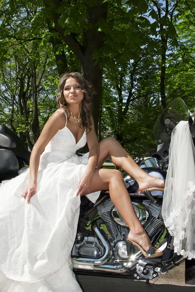 Mooie jonge bruid zittend op een motorfiets — Stockfoto