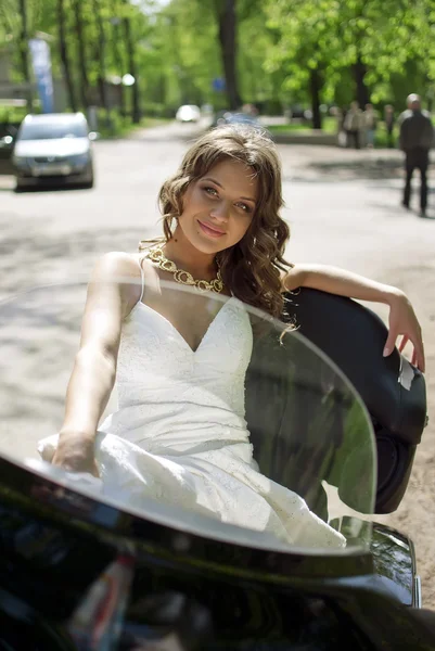 Όμορφη νεαρή νύφη που κάθεται σε μια μοτοσικλέτα — Φωτογραφία Αρχείου