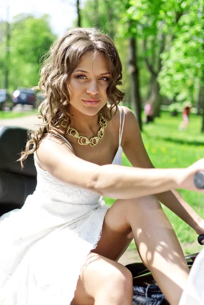 Linda jovem noiva sentada em uma motocicleta — Fotografia de Stock