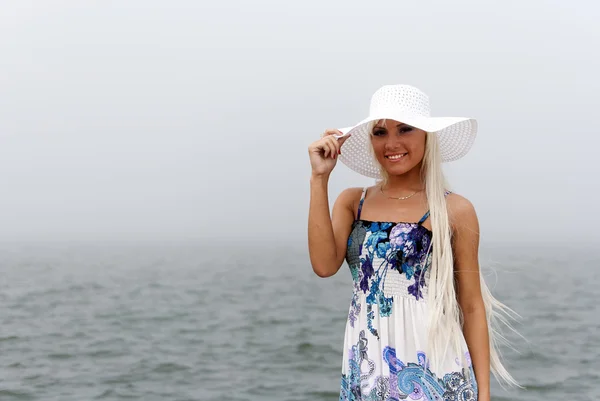 Girl in hat standing in the misty sea — Stock Photo, Image