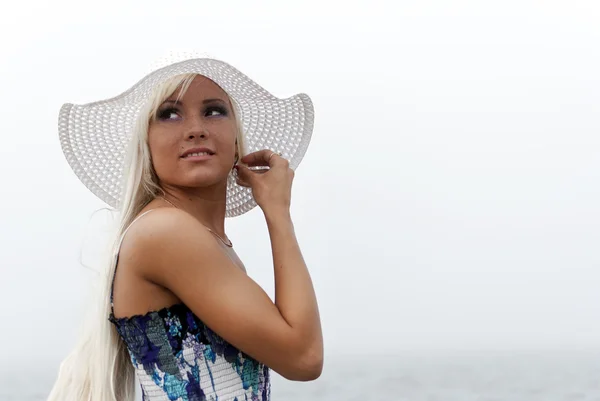 Chica en sombrero de pie en el mar brumoso — Foto de Stock