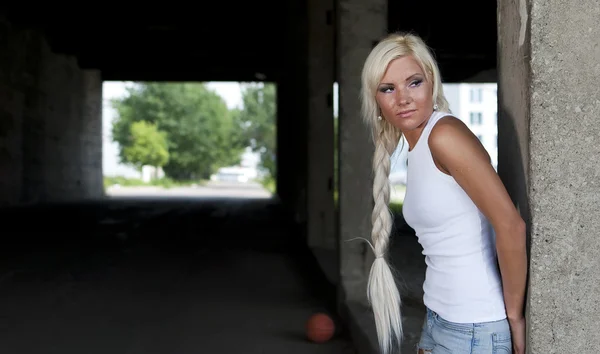 Gadis atletik dengan celana pendek denim dan kaos putih berdiri di tiang — Stok Foto