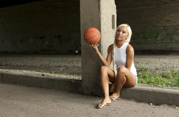 Gadis pirang cantik duduk dengan basket di jalan — Stok Foto