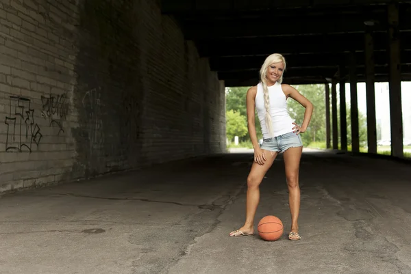 美しいブロンドの女の子は通りでバスケット ボールの側に立って — ストック写真