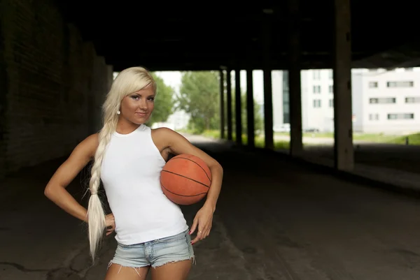 Vacker blond tjej som står med basket i gatan — Stockfoto