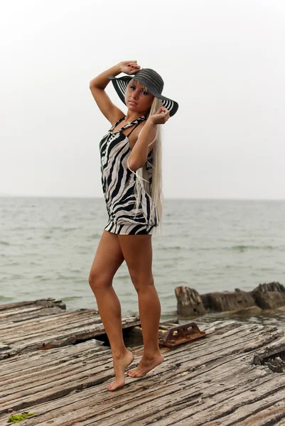 Denizde kırık bir gemide duran şapkalı kız — Stok fotoğraf