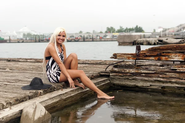 Kırık bir gemiyle denize oturan şapkalı kız — Stok fotoğraf