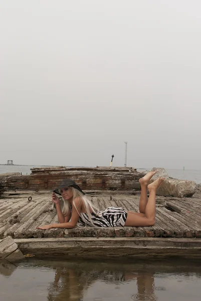 Lány egy kalap feküdt egy törött hajó a tengeren — Stock Fotó