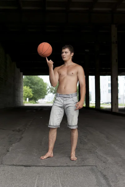 Killen som innehar basket på fingret — Stockfoto