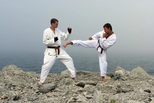 Dua karateka bertarung di tepi laut berkabut — Stok Foto