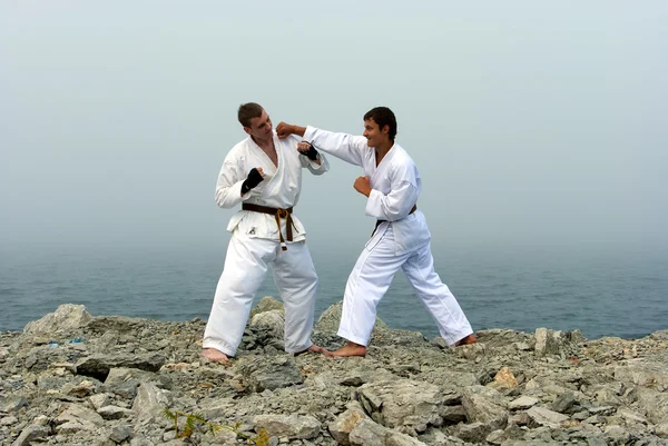 Två karateka kampen på packar ihop av det dimmiga havet — Stockfoto
