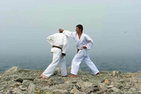Due karateka combattono sulle rive del mare nebbioso — Foto Stock