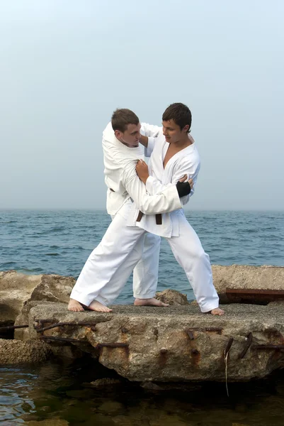 Dois karateka lutam nas margens do mar nebuloso — Fotografia de Stock