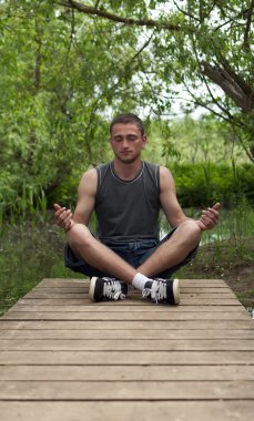adam lotus pozisyonda oturan ve meditasyon
