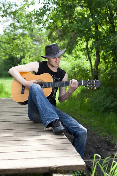 남자가 숲 속에서 기타를 연주 — 스톡 사진