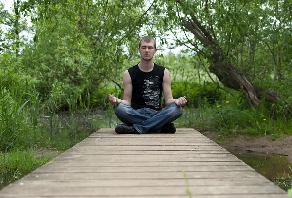 Homem sentado na posição de lótus e medita — Fotografia de Stock