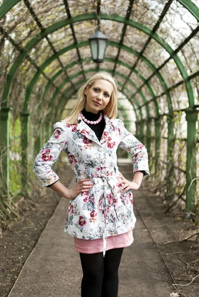 Blond tjej står i en gränd i parken — Stockfoto