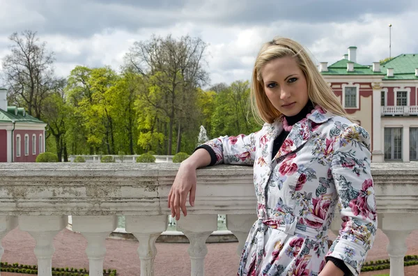 Блондинка, стоящая на фоне старого дворца — стоковое фото
