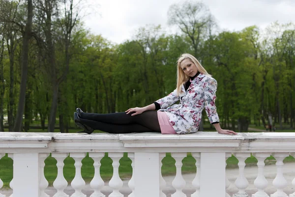 Blond tjej sitter på räcket — Stock fotografie
