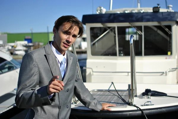 Man in a gray business suit near the yacht — Stock Photo, Image