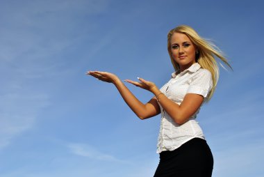 Blonde girl in a white shirt against the sky. Suited for advertising. Space clipart