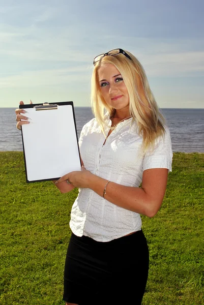 Девушка держит чистую бумагу у моря — стоковое фото