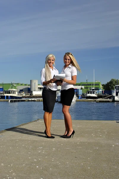 Two girls with the documents standing on the pier — Stock Photo, Image