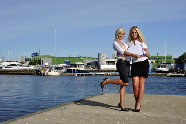 Zwei Mädchen mit den Dokumenten stehen auf der Seebrücke — Stockfoto