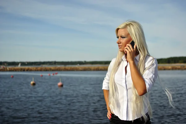 Sahilde bir cep telefonuyla konuşurken kız — Stok fotoğraf