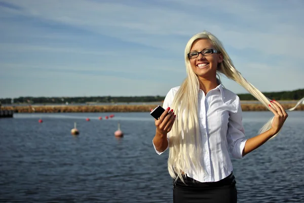 Девушка с мобильным телефоном на пляже — стоковое фото