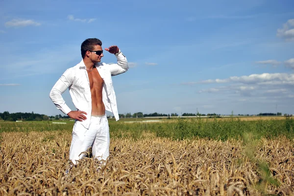 Bodybuilder dressed in white on the field — Stock Photo, Image